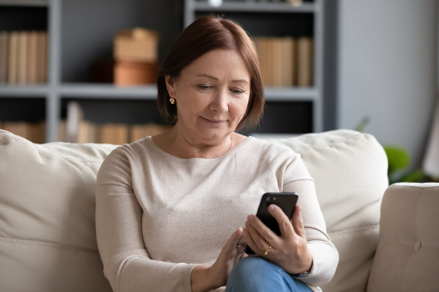 Eine Patientin sucht von zu Hause aus Informationen oder eine Praxis für ihre gesundheitlichen Anliegen auf dem Smartphone.